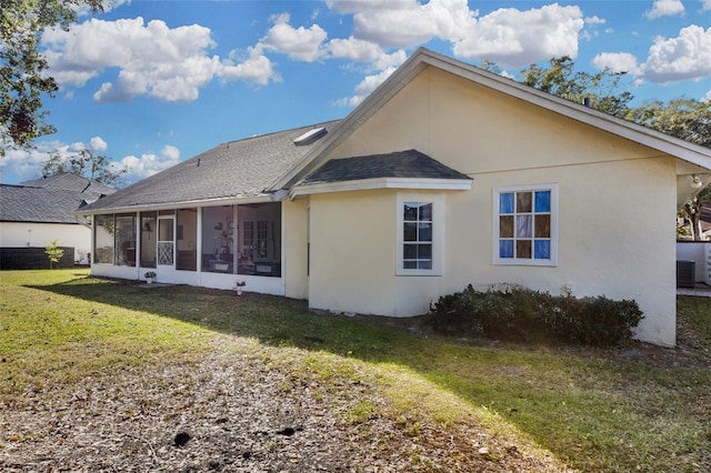 rear view of house with a lawn and a sunroom