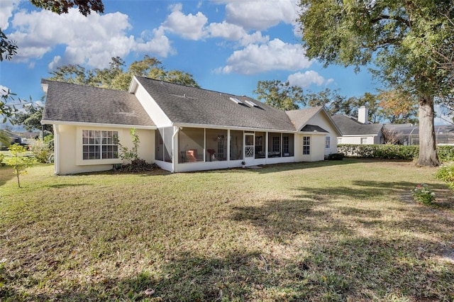 rear view of house featuring a sunroom and a yard