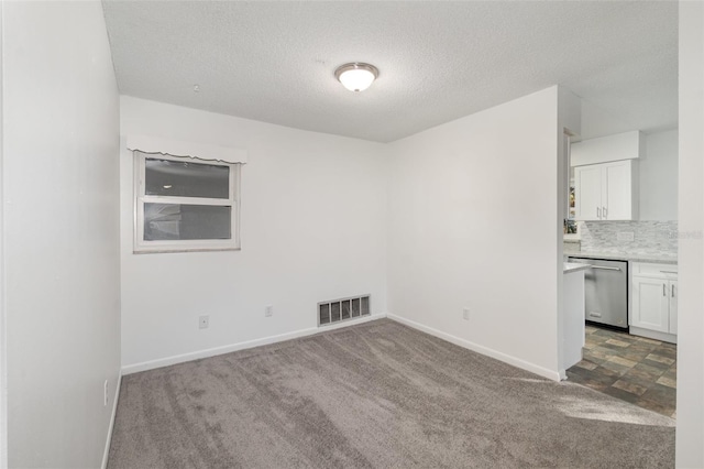 carpeted spare room with a textured ceiling