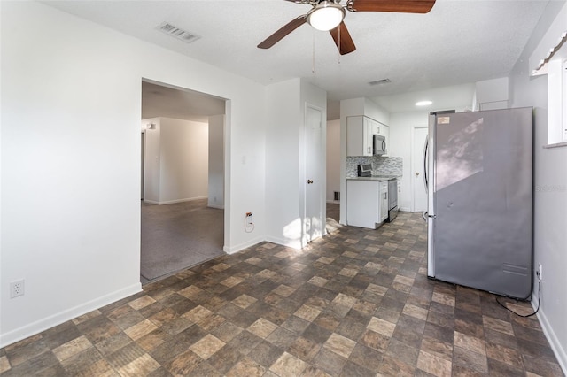 kitchen featuring backsplash, a textured ceiling, stainless steel appliances, ceiling fan, and white cabinets