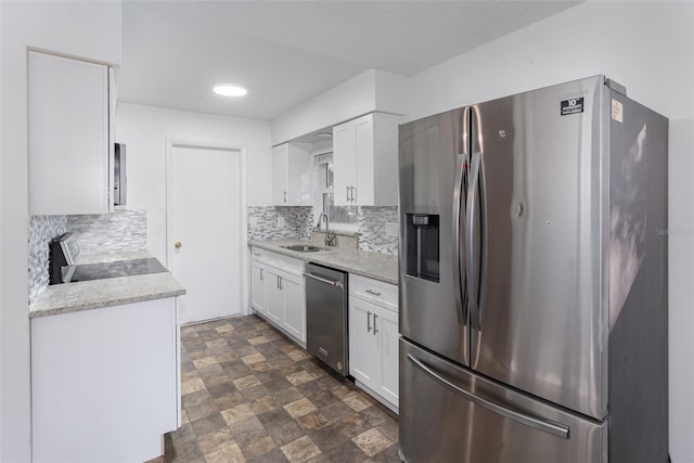 kitchen with white cabinets, backsplash, sink, and stainless steel appliances