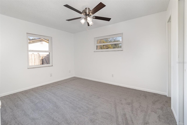 carpeted spare room featuring ceiling fan and a textured ceiling