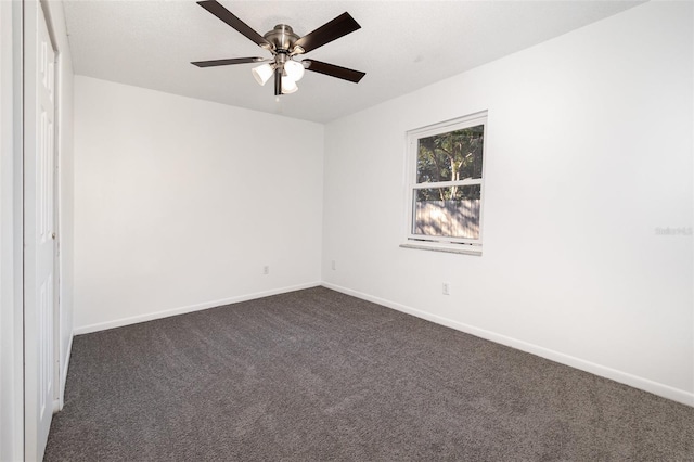 unfurnished room featuring dark colored carpet and ceiling fan