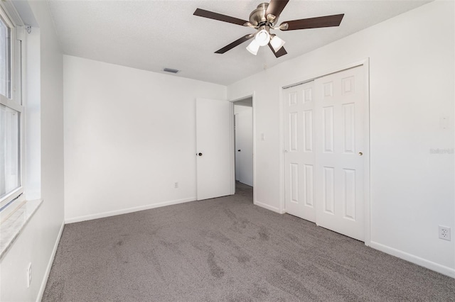 unfurnished bedroom featuring ceiling fan, a closet, and carpet floors