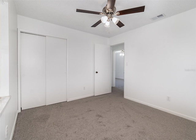 unfurnished bedroom featuring ceiling fan, a closet, and carpet floors