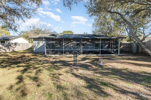 back of property featuring a sunroom and a lawn