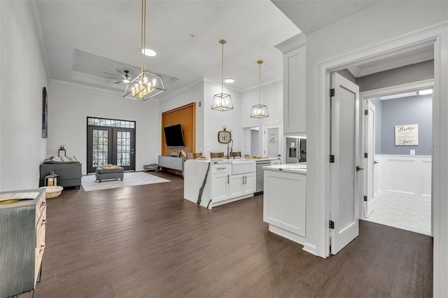 kitchen with dark hardwood / wood-style floors, decorative light fixtures, white cabinetry, stainless steel dishwasher, and french doors