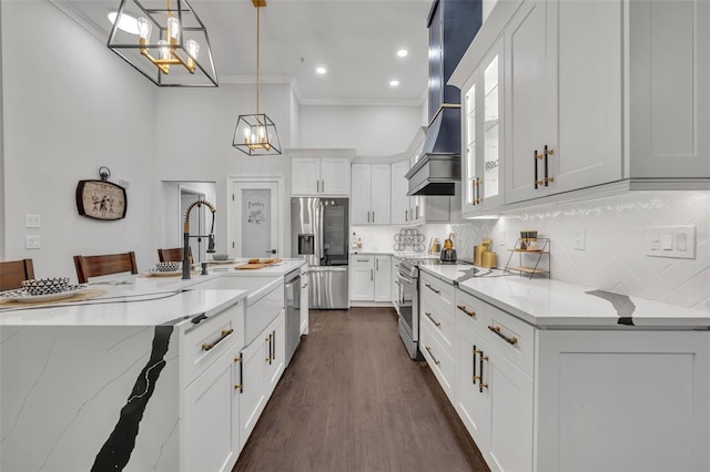 kitchen featuring a kitchen bar, hanging light fixtures, stainless steel appliances, decorative backsplash, and white cabinets