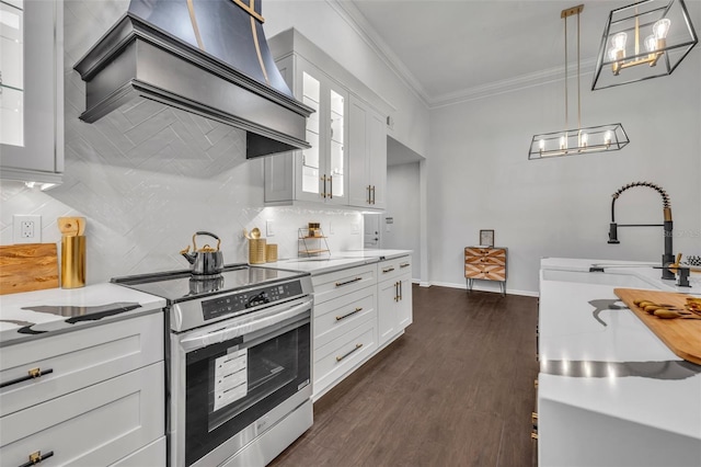 kitchen with hanging light fixtures, electric range, custom range hood, decorative backsplash, and white cabinets