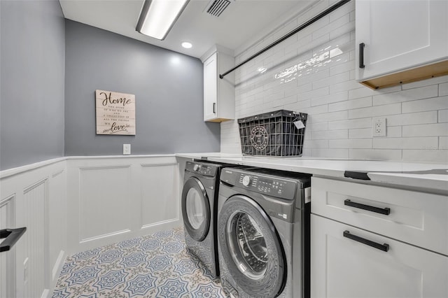 clothes washing area featuring cabinets and independent washer and dryer