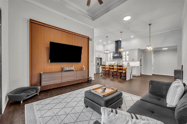 living room with ceiling fan, ornamental molding, sink, and hardwood / wood-style floors