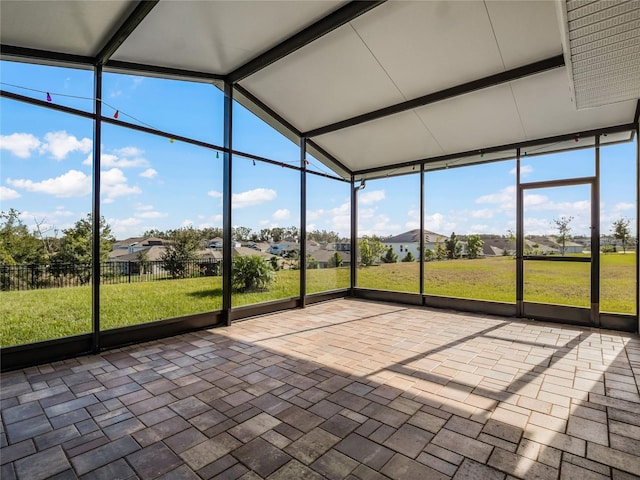 unfurnished sunroom featuring lofted ceiling