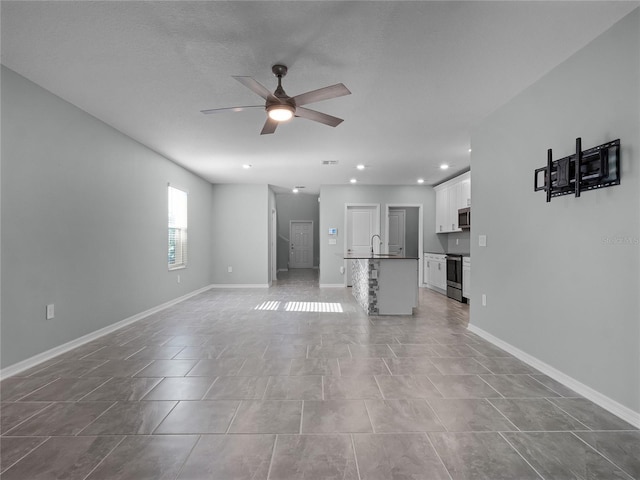 unfurnished living room featuring a textured ceiling, ceiling fan, and sink