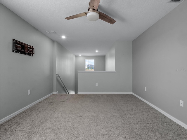 unfurnished room with ceiling fan, carpet floors, and a textured ceiling