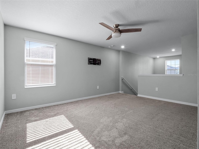 carpeted spare room with ceiling fan and a textured ceiling