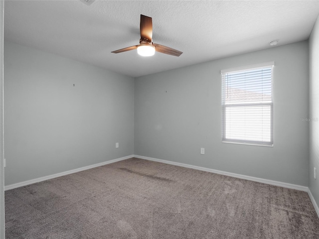 carpeted spare room featuring a textured ceiling and ceiling fan