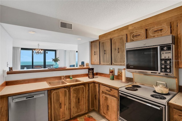 kitchen featuring dishwasher, sink, a notable chandelier, white range with electric stovetop, and a water view