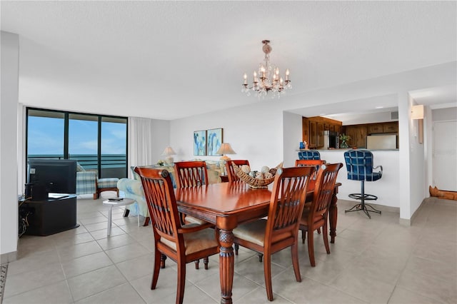 dining room with floor to ceiling windows, a textured ceiling, and an inviting chandelier