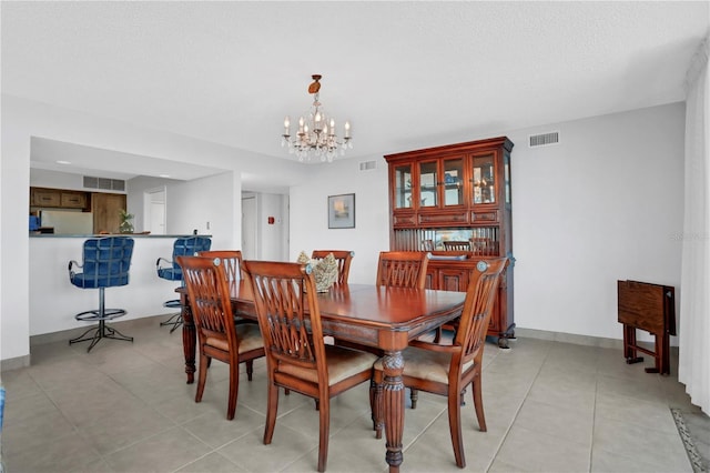 dining room with light tile patterned floors, a chandelier, and a textured ceiling