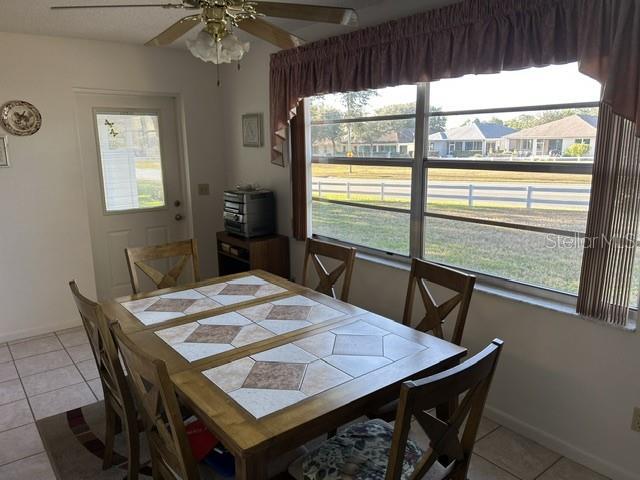 dining room with ceiling fan and light tile patterned floors