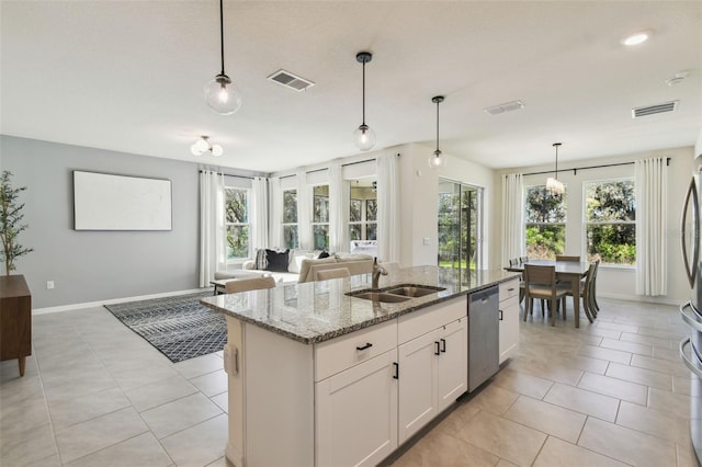 kitchen featuring light stone countertops, sink, decorative light fixtures, dishwasher, and white cabinetry