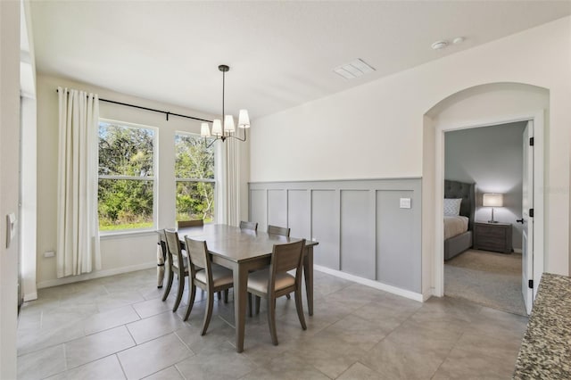 tiled dining area featuring a chandelier