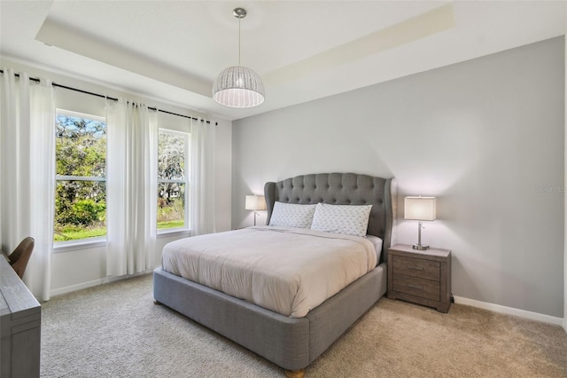 carpeted bedroom with a tray ceiling