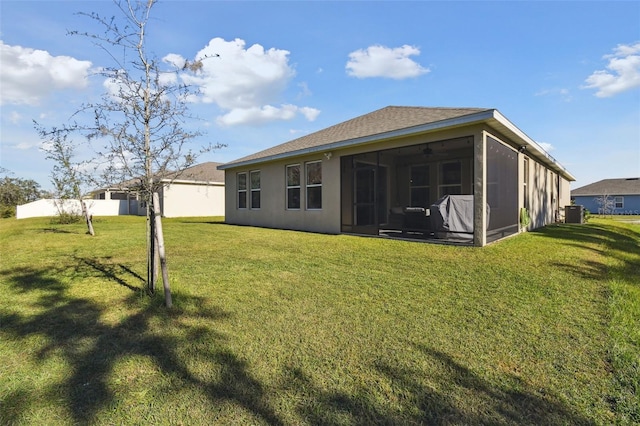 rear view of property featuring a sunroom and a yard