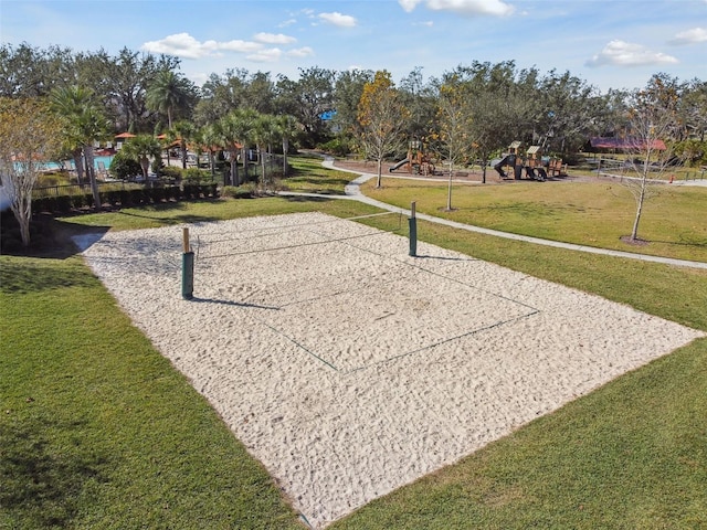 view of home's community featuring volleyball court, a playground, and a lawn