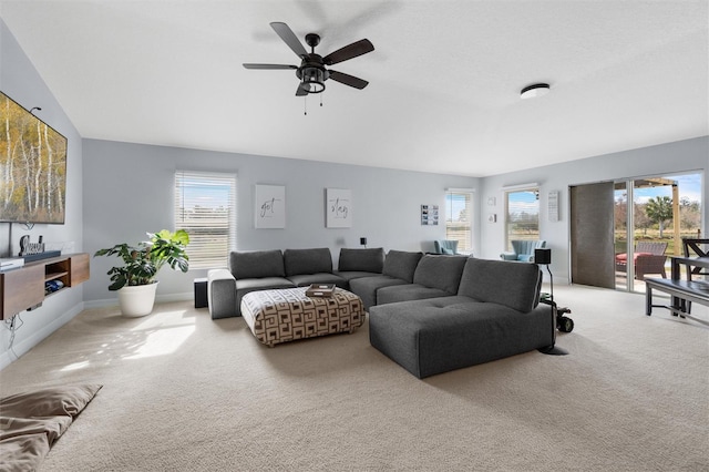 carpeted living room with ceiling fan