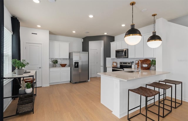 kitchen featuring white cabinetry, kitchen peninsula, sink, and appliances with stainless steel finishes