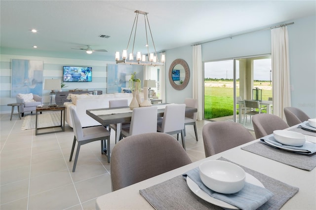 tiled dining room featuring ceiling fan with notable chandelier