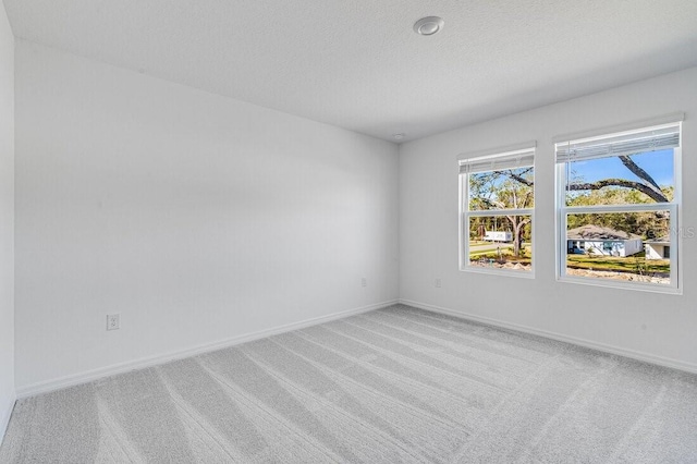 carpeted spare room with a textured ceiling