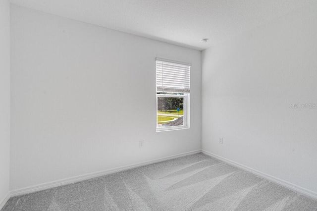 spare room featuring carpet floors and a textured ceiling