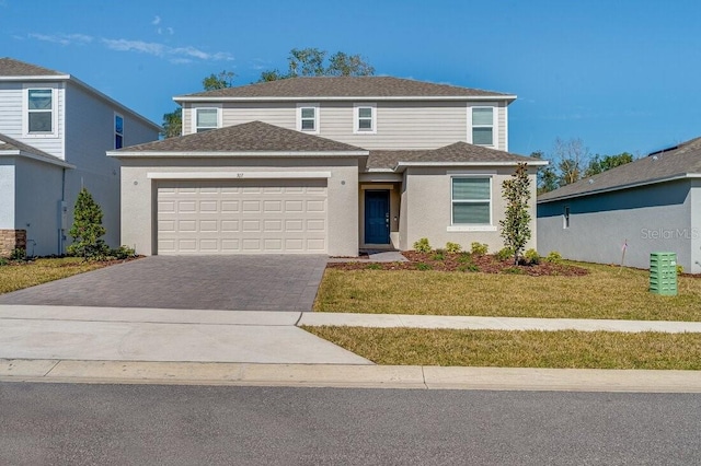 view of front property featuring a garage and a front lawn