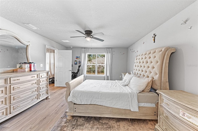 bedroom with light wood-type flooring, a textured ceiling, and ceiling fan