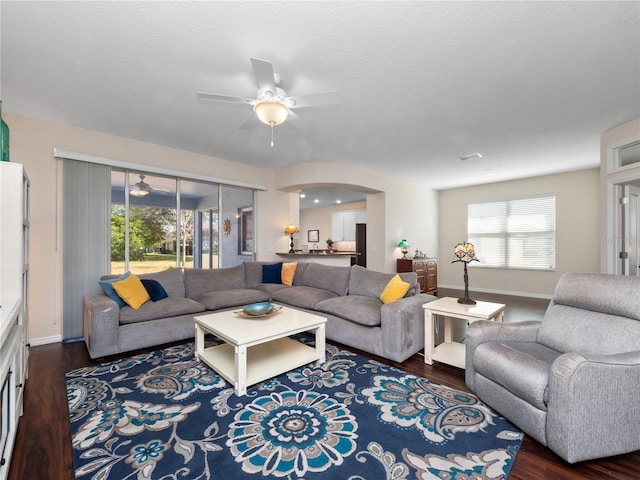 living room featuring ceiling fan and dark hardwood / wood-style flooring