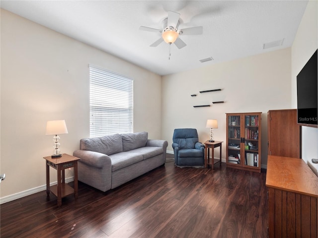 living room featuring ceiling fan and dark hardwood / wood-style flooring