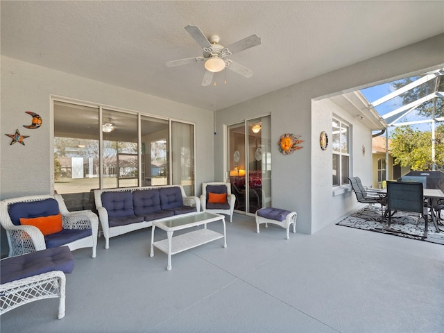 view of patio / terrace with ceiling fan, an outdoor living space, and glass enclosure