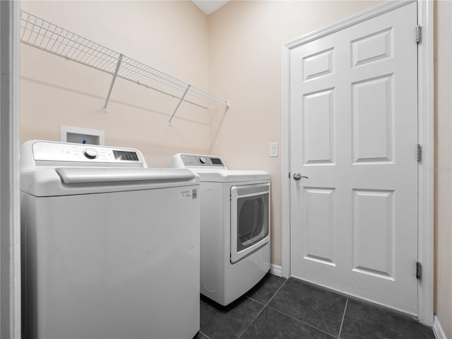 clothes washing area featuring independent washer and dryer and dark tile patterned floors