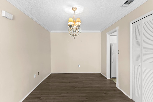 unfurnished dining area featuring dark hardwood / wood-style flooring, a chandelier, a textured ceiling, and ornamental molding