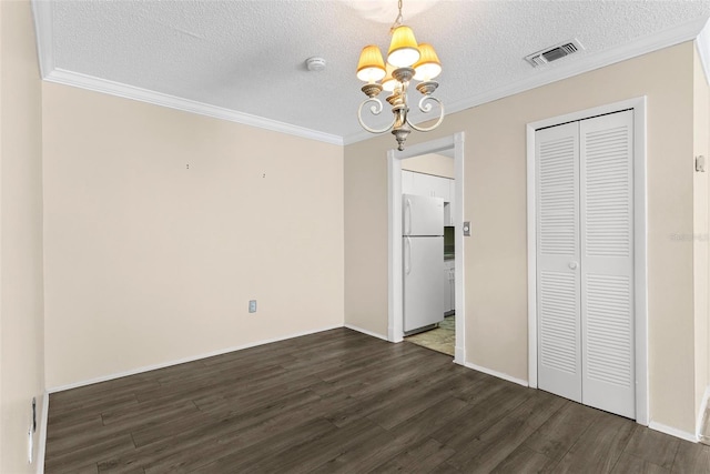 unfurnished dining area with a chandelier, a textured ceiling, dark hardwood / wood-style flooring, and ornamental molding