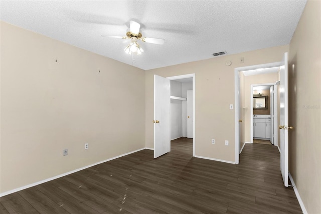 unfurnished bedroom featuring ceiling fan, dark hardwood / wood-style flooring, and a textured ceiling