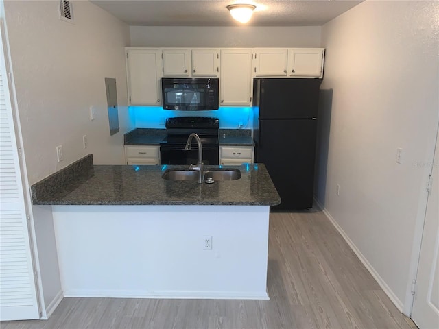 kitchen with kitchen peninsula, light wood-type flooring, sink, black appliances, and white cabinets