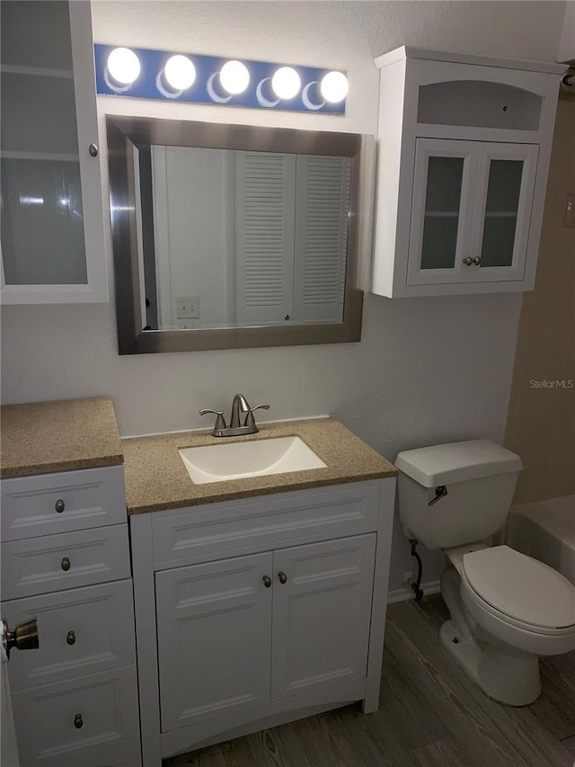 bathroom featuring hardwood / wood-style floors, vanity, and toilet