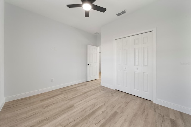 unfurnished bedroom featuring ceiling fan, light hardwood / wood-style flooring, and a closet