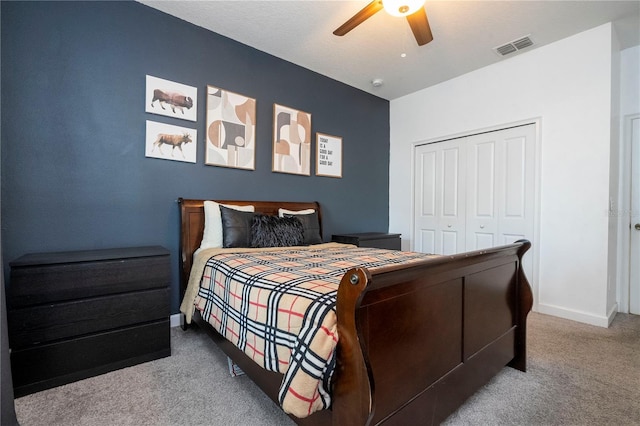 bedroom featuring ceiling fan, light colored carpet, and a closet