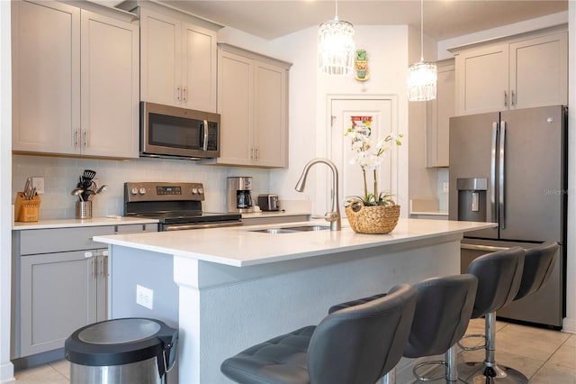 kitchen featuring backsplash, sink, gray cabinets, light tile patterned floors, and appliances with stainless steel finishes