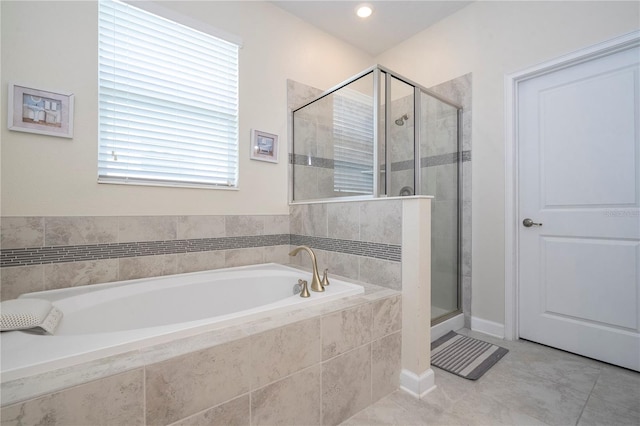 bathroom featuring tile patterned flooring, separate shower and tub, and a wealth of natural light