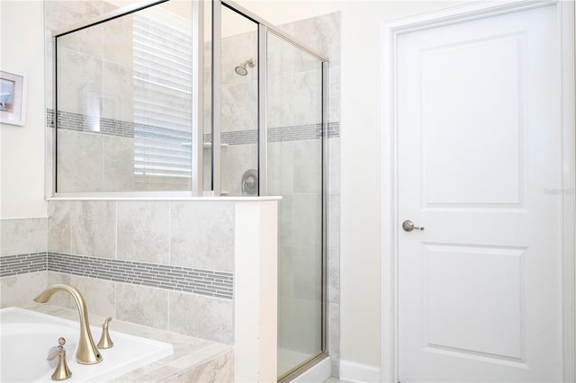 bathroom featuring shower with separate bathtub